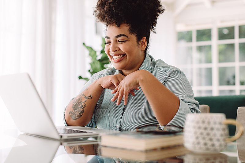 Female real estate student that is using a laptop to take a real estate course on the Eagle Learning Institute platform.